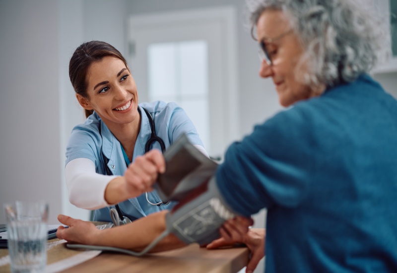 Nurse checks a senior woman’s blood pressure to support preventing hypertension in Peoria, AZ